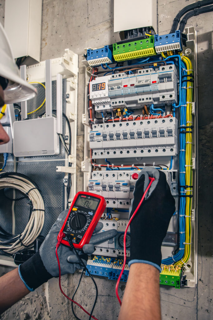 man, an electrical technician working in a switchboard with fuses. man, an electrical technician working in a switchboard with fuses.